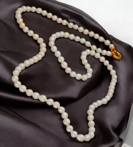 collar de perlas 7-7.50 mm de 84 cm. de largo sobre paño de seda