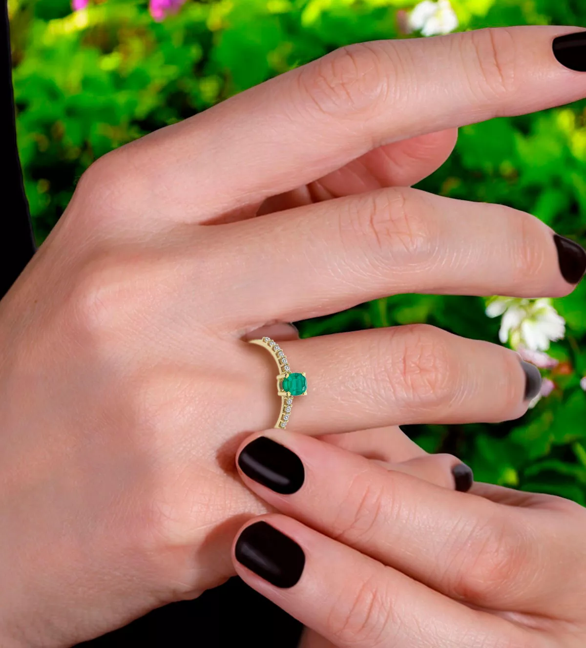 anillo de oro con esmeralda y circones foto en mano de mujer