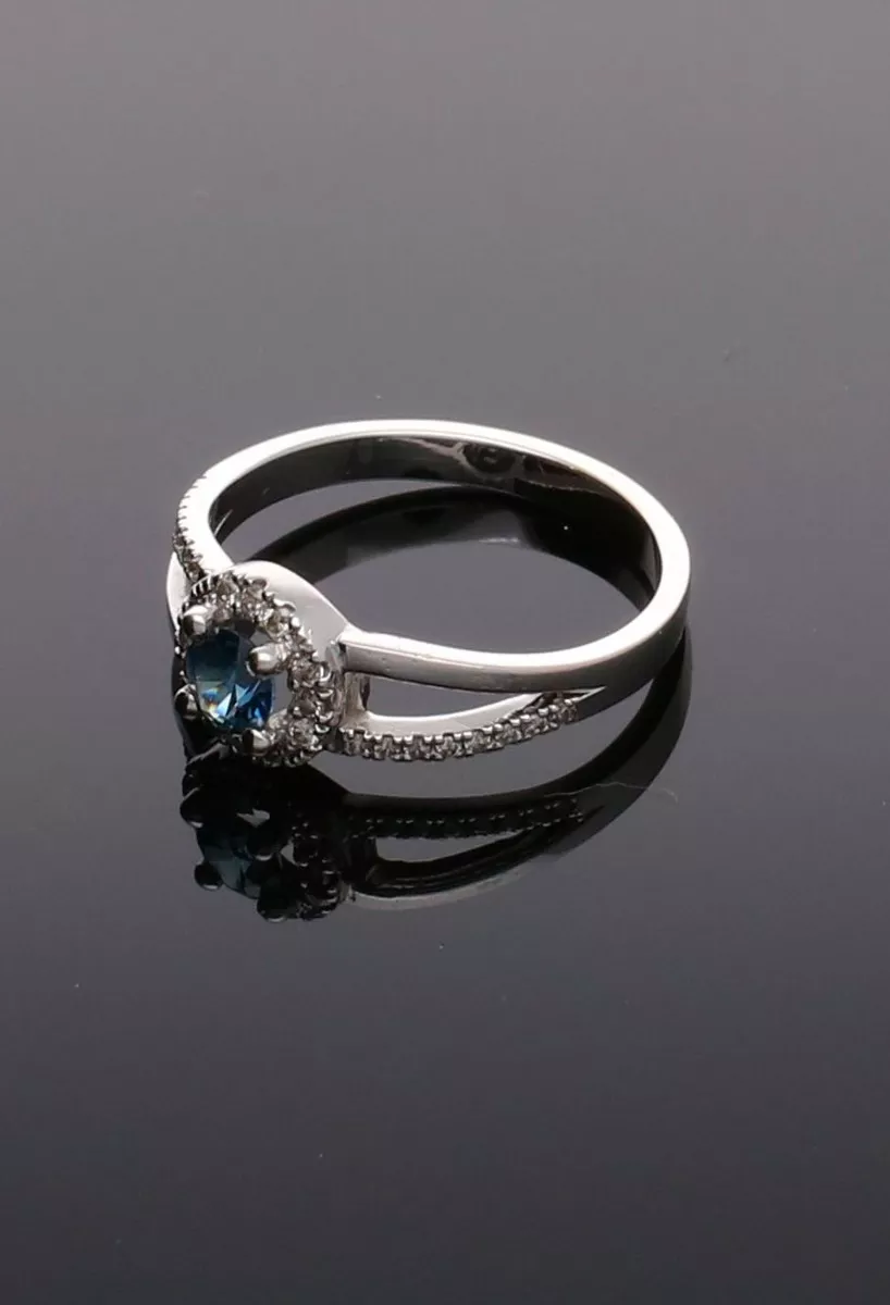 anillo oro blanco 18ktes con zafiro y diamantes vista sin recortar fondo negro