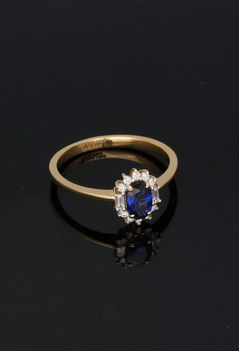 Anillo de oro amarillo 18 ktes con zafiro y diamantes vista sin recortes sobre fondo negro