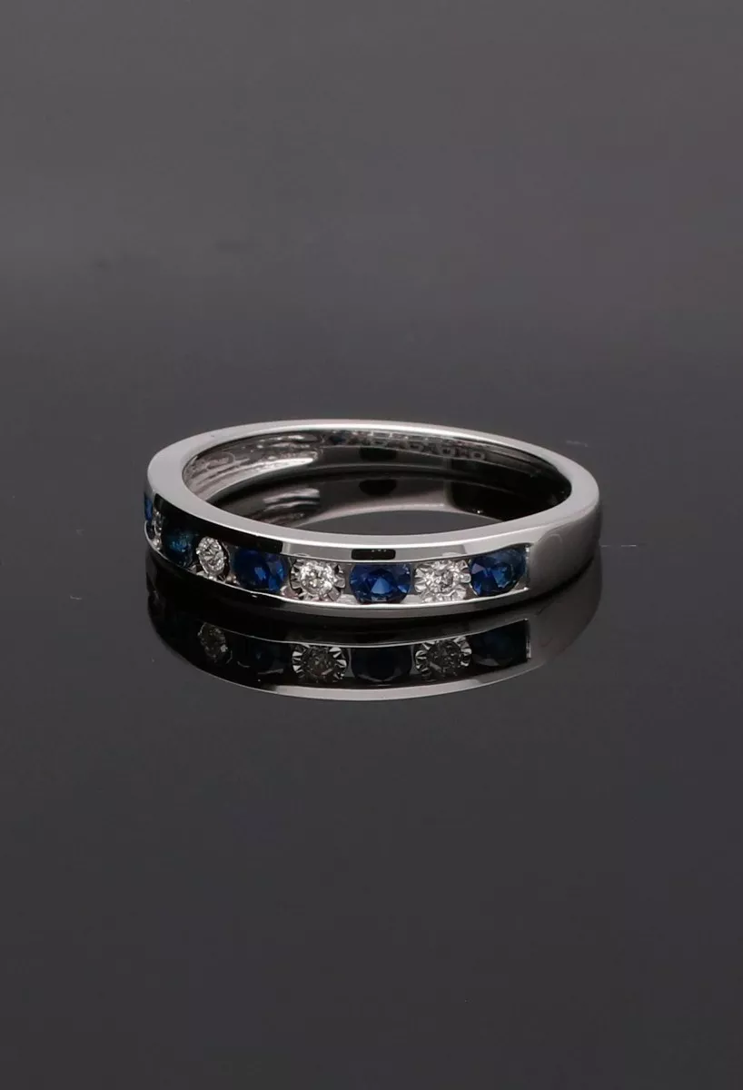 anillo media alianza de oro blanco 18 ktes con zafiros y diamantes fotografia sobre fondo negro