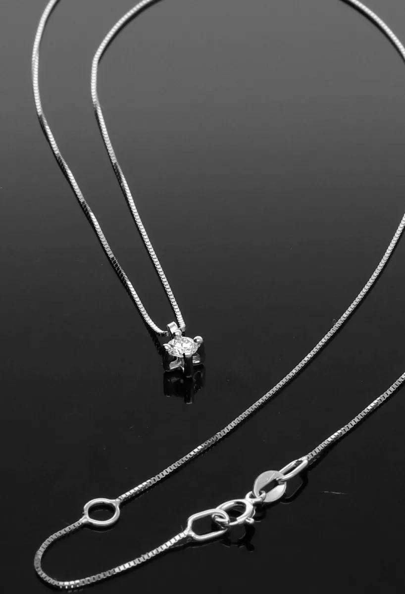 gargantilla oro blanco 18 ktes con diamante talla brillante engastado en garra de 4 patas vista sin recortes sobre fondo negro.