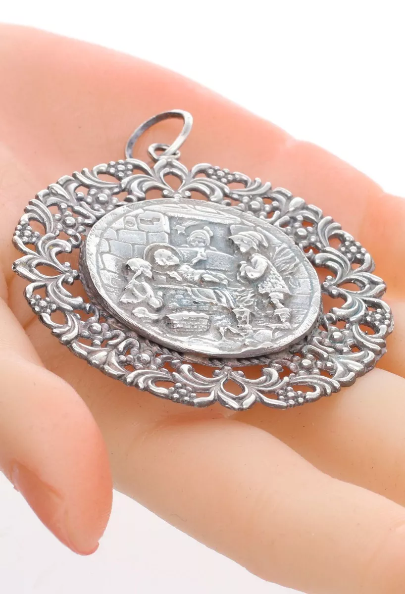 Medalla de cuna del niño en el pesebre en plata de ley 297_870678 en mano
