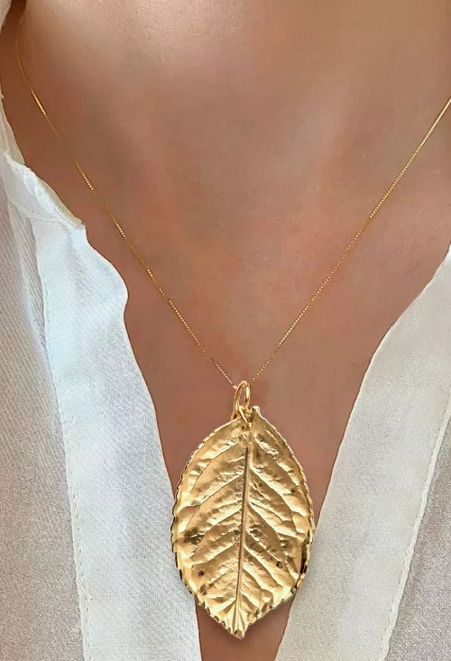 colgante hoja natural metalizada chapada oro toma con modelo femenino