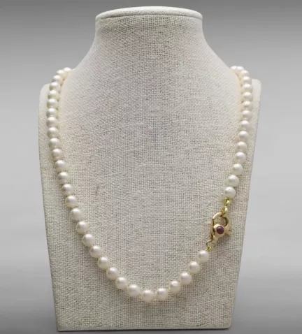 collar de perlas akoya con mosqueton de rubies vista en peto
